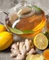Cup of ginger tea with honey and lemon on wooden table